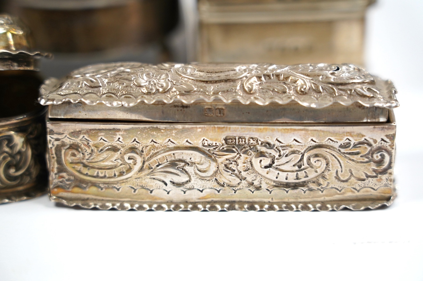 Two late Victorian repousse silver trinket boxes, largest 13.3cm, a pair of George V silver trinket boxes and a tortoiseshell and silver mounted circular trinket box. Condition - poor to fair